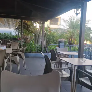 Covered terrace at Bar Rodrigues in Caniço de Baixo, with Delta chairs, tables and tropical garden planting