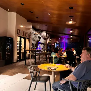 Capoeira Lounge interior in Caniço at night, with a live band, purple stage lighting, timber ceiling and an exposed rock wall