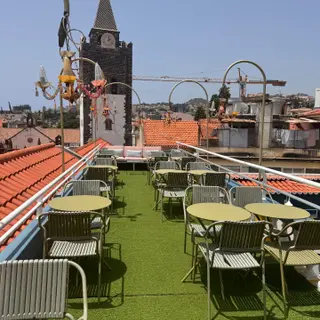 Flamingo Cocktail Bar rooftop terrace at Sé Boutique Hotel, Funchal, with Sé Cathedral tower behind the tables