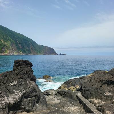 Atlantic view from the lava rocks at Praia da Laje in Seixal, Madeira, toward the Ilheus da Ribeira da Janela sea stacks