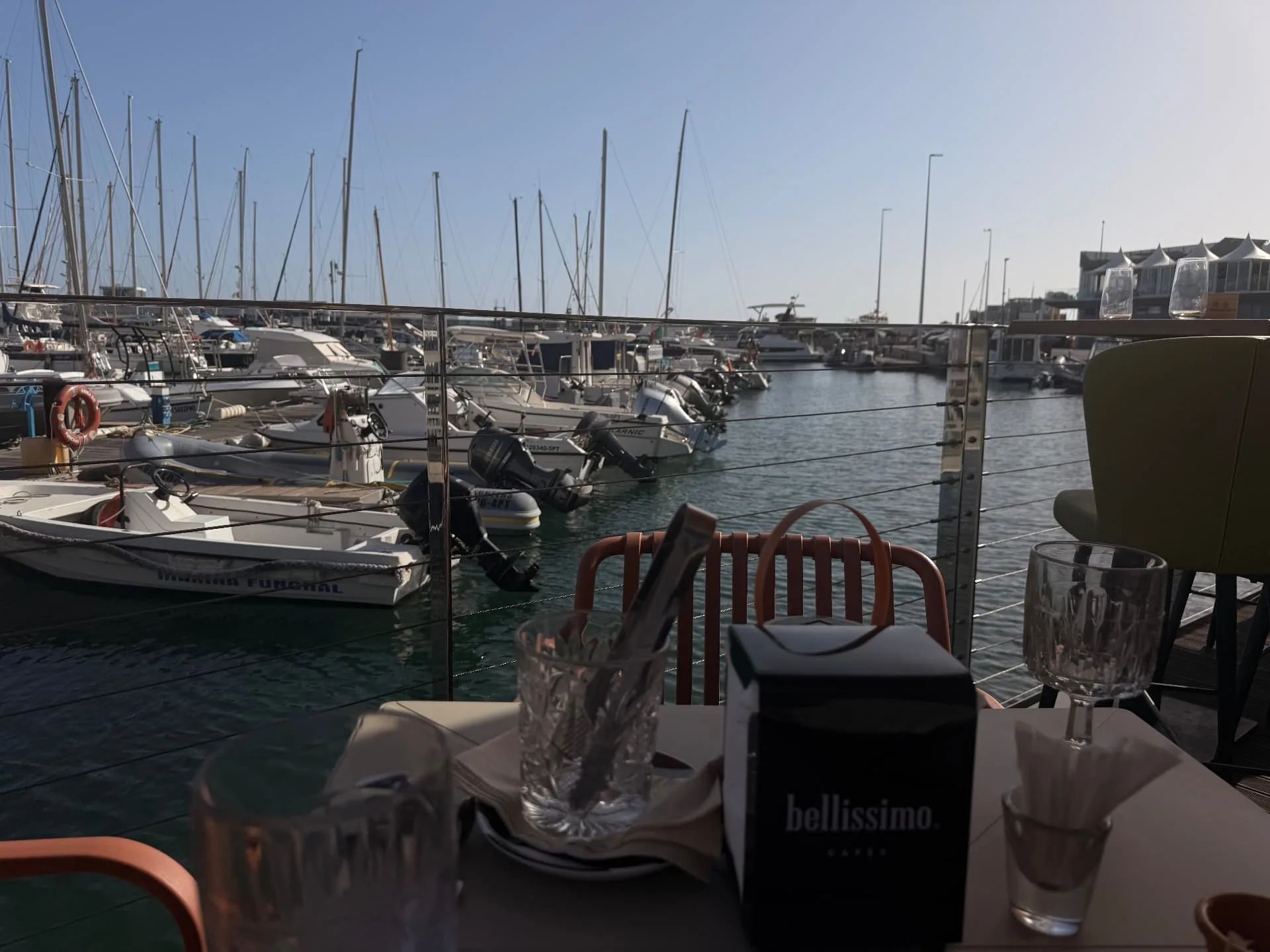 Latitude 32° terrace table beside moored boats at Funchal Marina