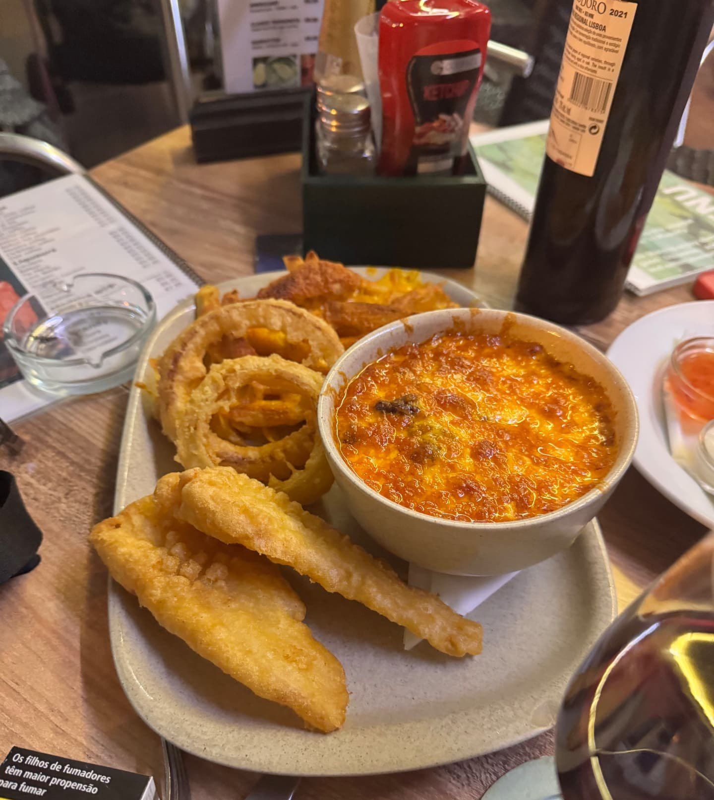 Battered fish, crispy onion rings and a cheesy baked pasta dish served with Portuguese red wine at Moynihan's Irish Bar in Funchal, Madeira