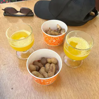 Fresh passion fruit poncha with boiled peanuts in their shells at Rei da Poncha bar in Funchal, Madeira
