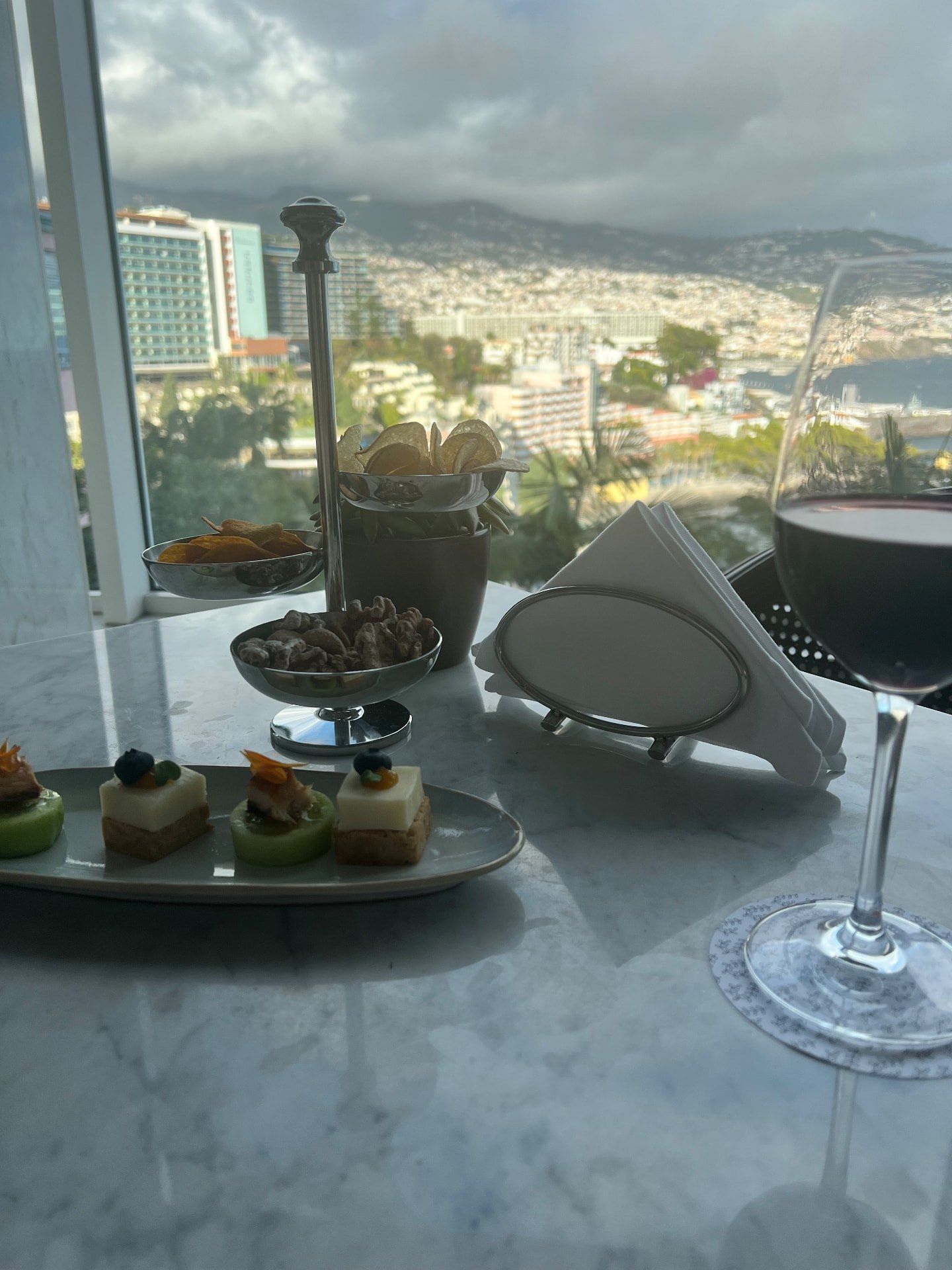 Wine, canapes and nuts served at Reids Palace Champagne Bar with panoramic views over Funchal and the Atlantic, Madeira