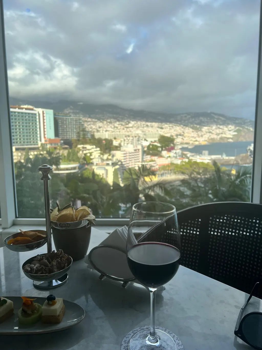 Glass of red wine at Reid's Palace Champagne Bar overlooking Funchal and its marina
