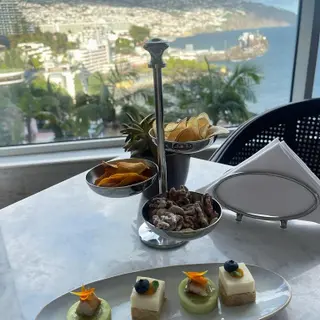 Champagne bar canapes, crisps and candied nuts with a panoramic view over Funchal Bay from Belmond Reids Palace Champagne Bar, Madeira