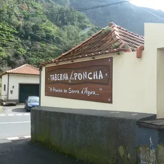 Wooden Taberna da Poncha sign on a cream wall beneath a tiled roof