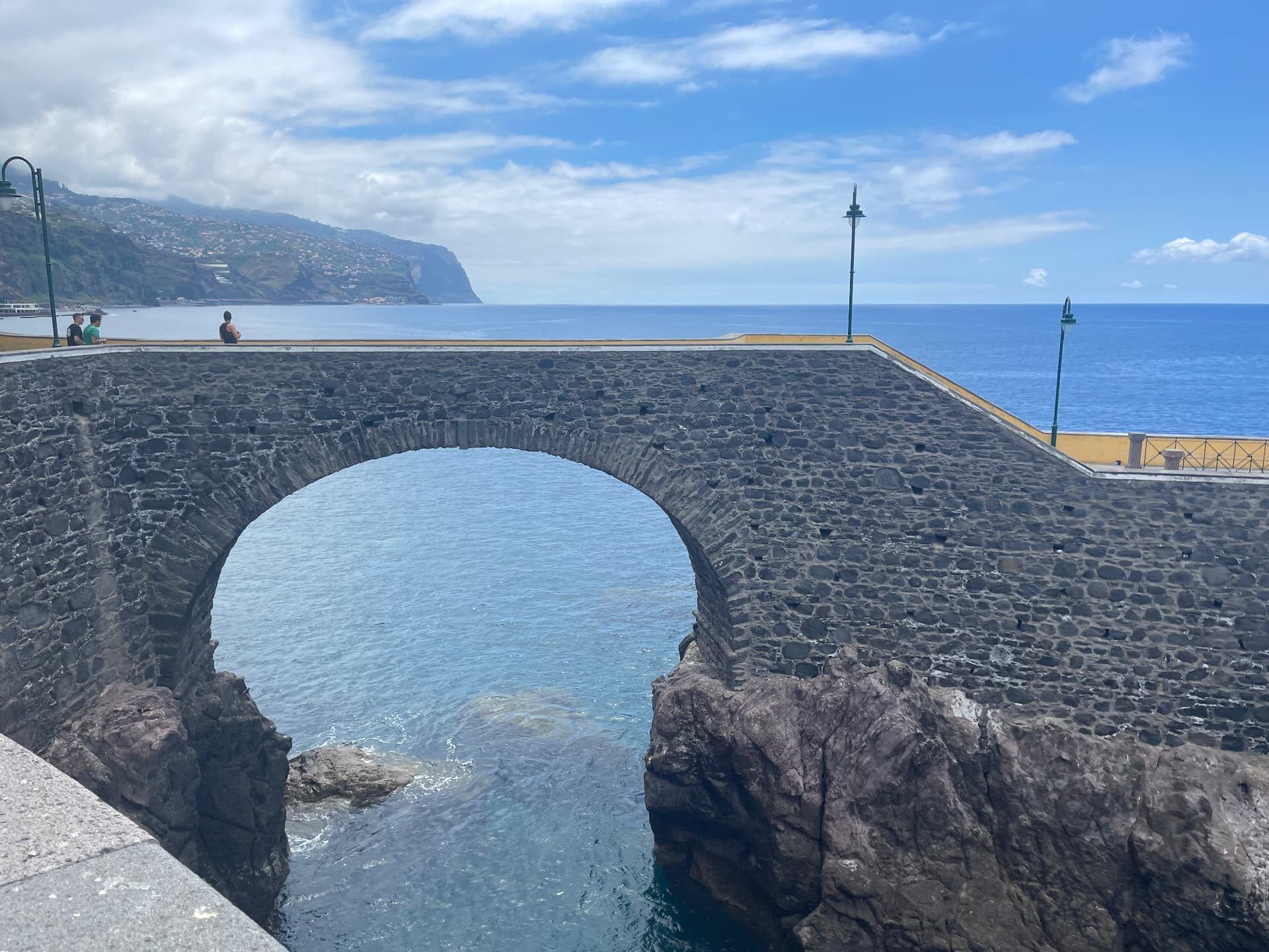The historic stone bridge at Praia da Ponta do Sol in sunshine