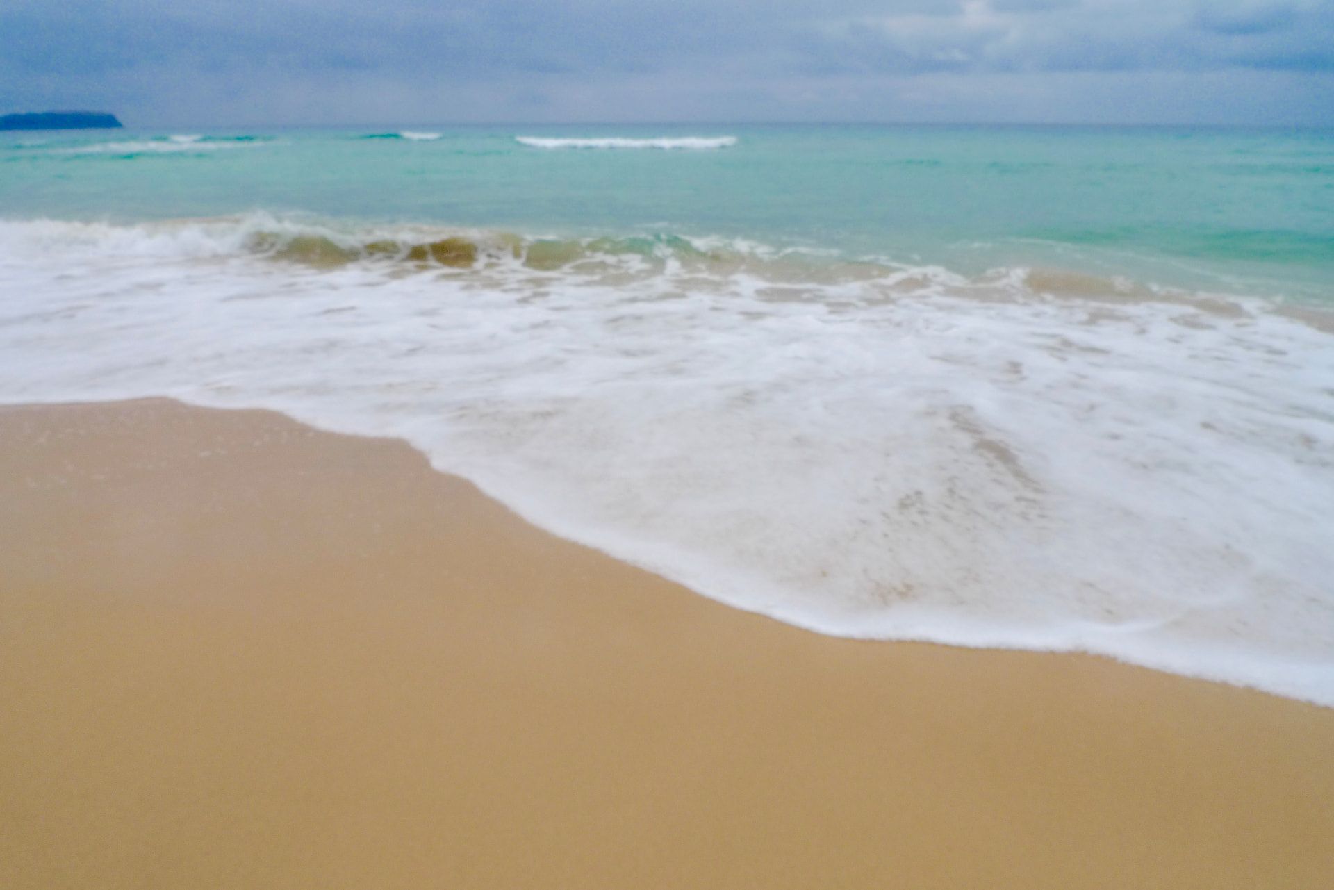 Turquoise shallows washing over the golden sand of Porto Santo beach.