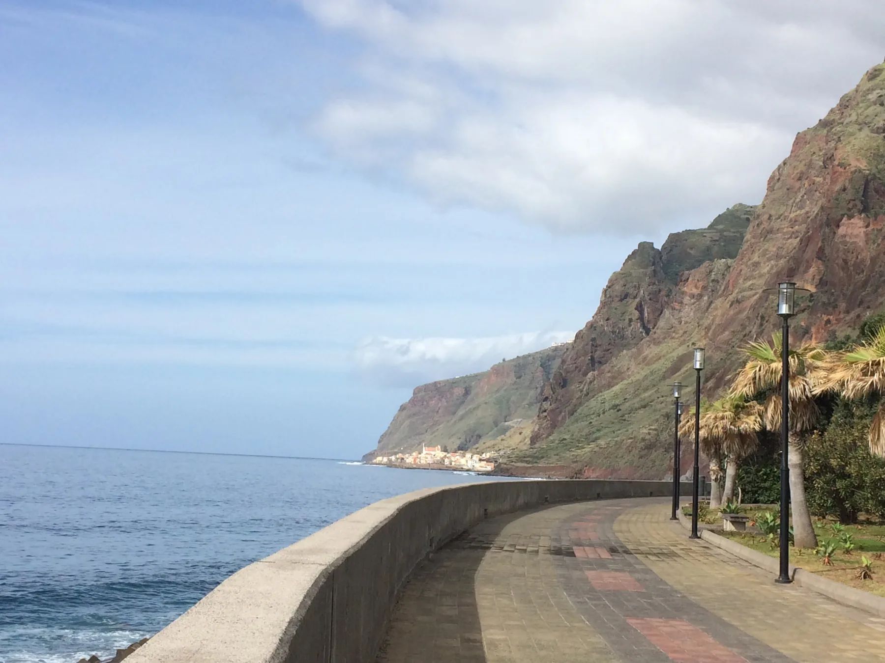 The seafront promenade at Jardim do Mar with palms and lamps, Paul do Mar visible along the cliffs