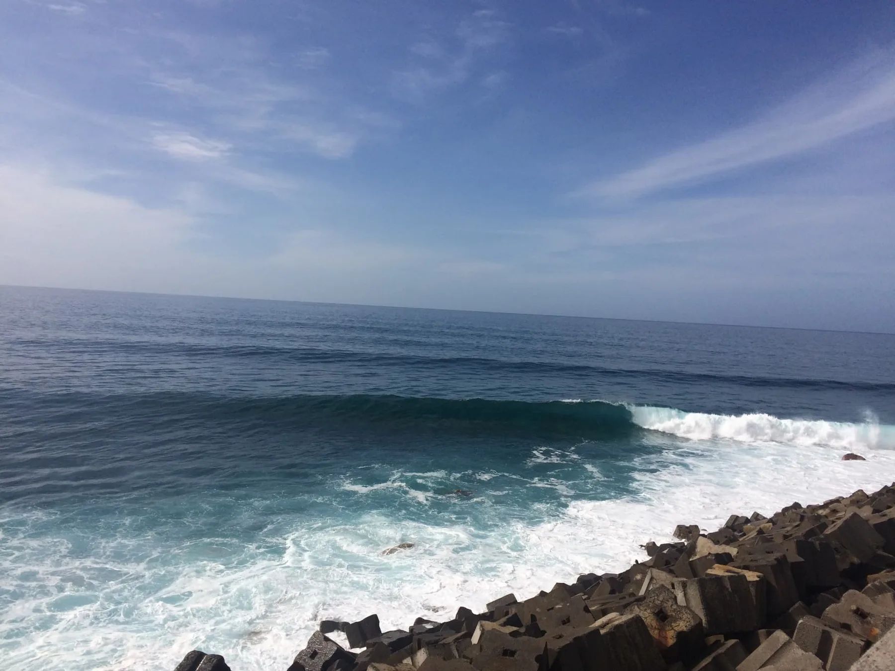 A clean green wave peeling along the rocks at Jardim do Mar