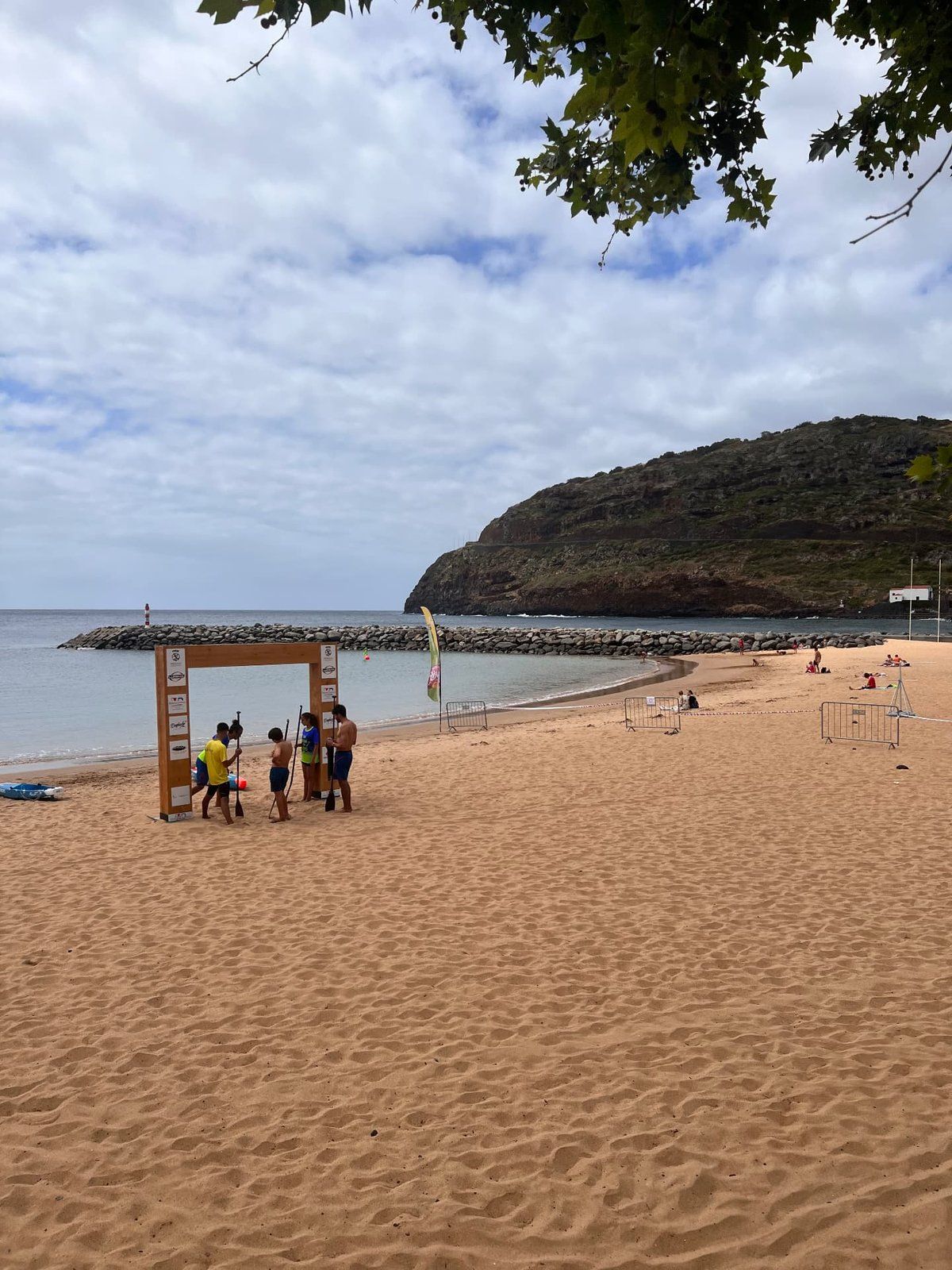 Golden sand of Praia de Machico beach curving around the bay towards the São Roque headland in Machico, Madeira
