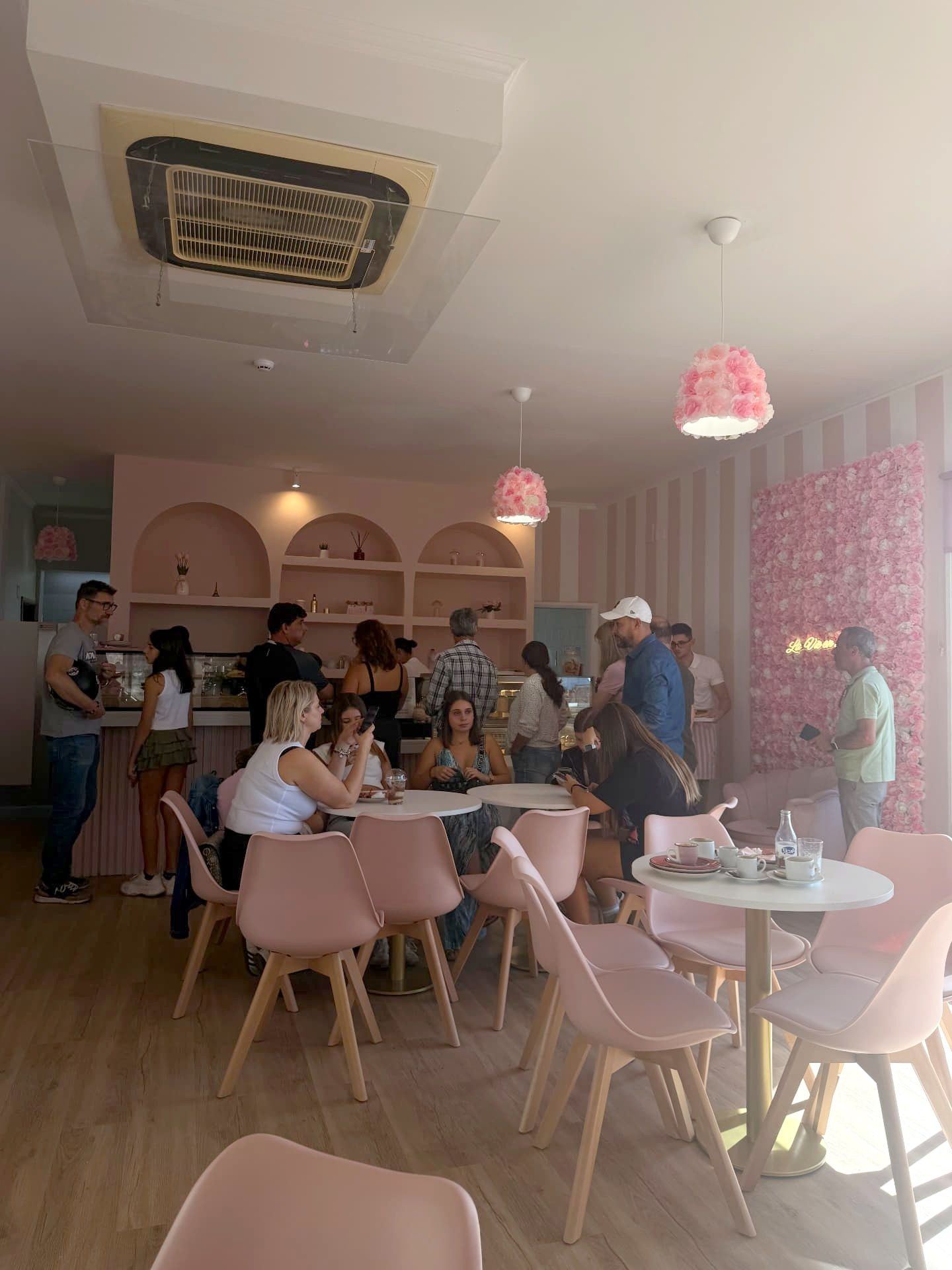 Busy counter and pink chairs at La Vie en Rose café and bakery, Caniço de Baixo