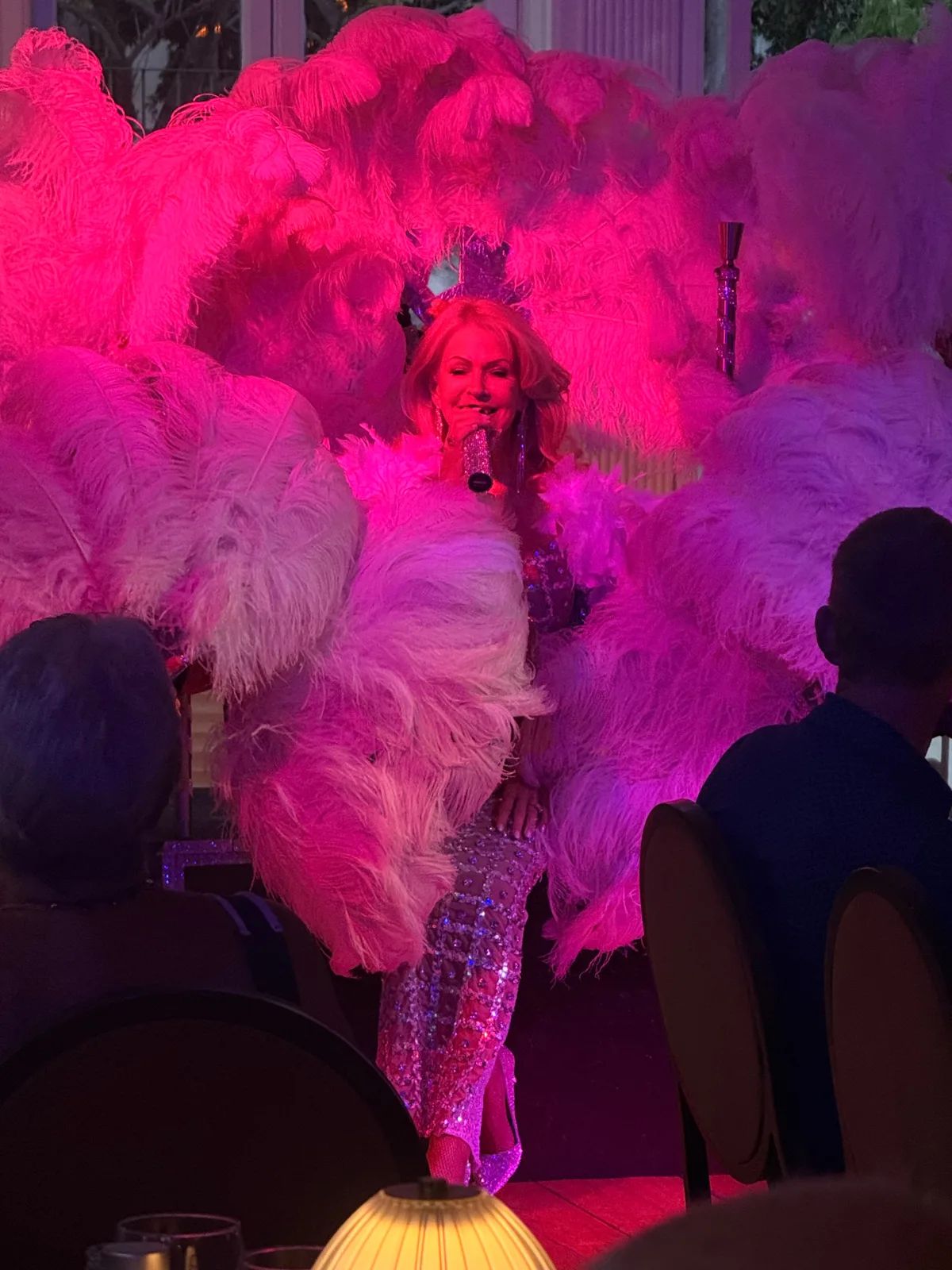 Singer Sian Lesley in a sequinned gown surrounded by large pink ostrich feather fans during her Saturday cabaret dinner show at The Ritz Madeira in Funchal
