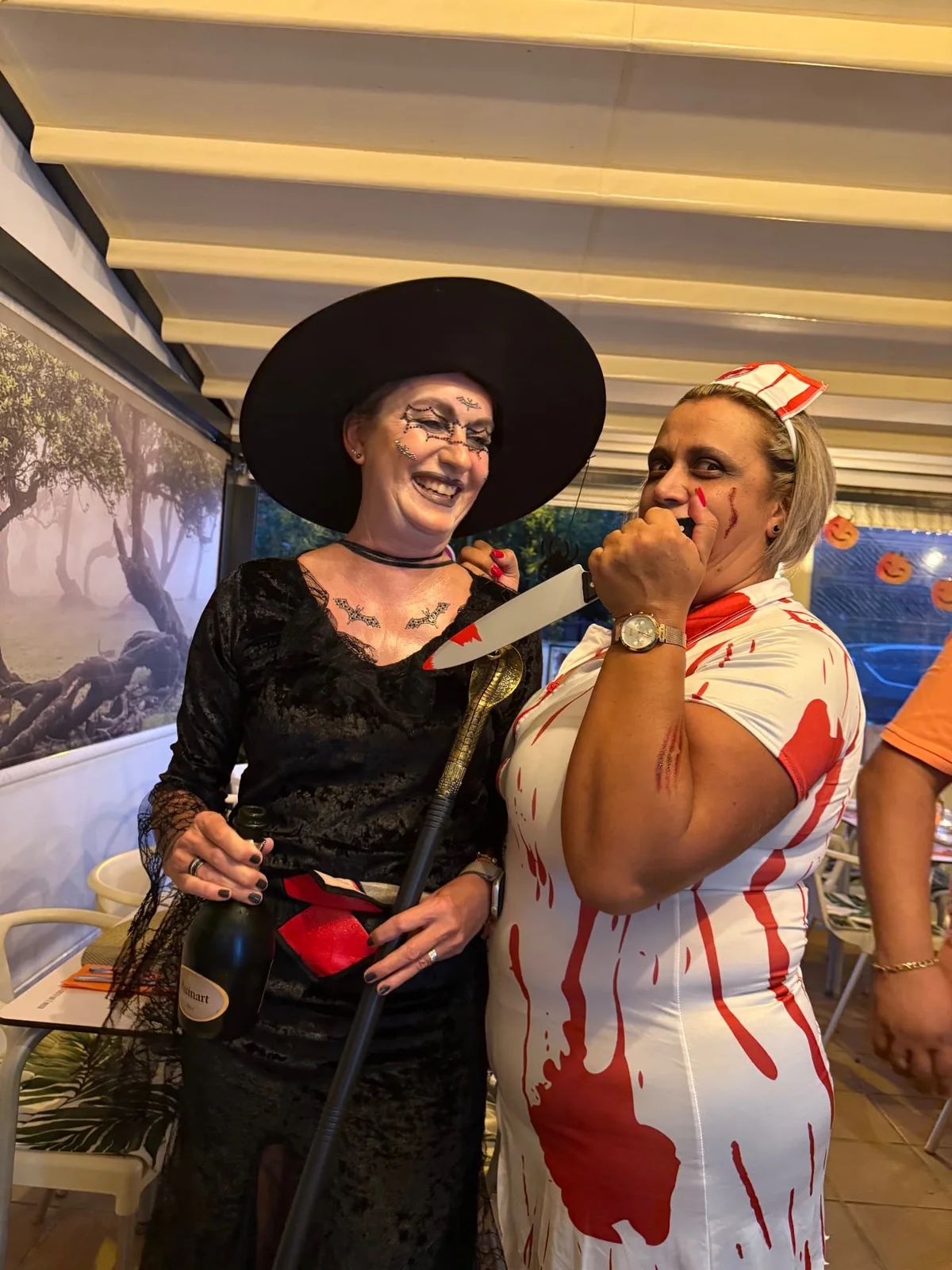 A witch and a nurse costume with a prop knife at Munchies in 2025