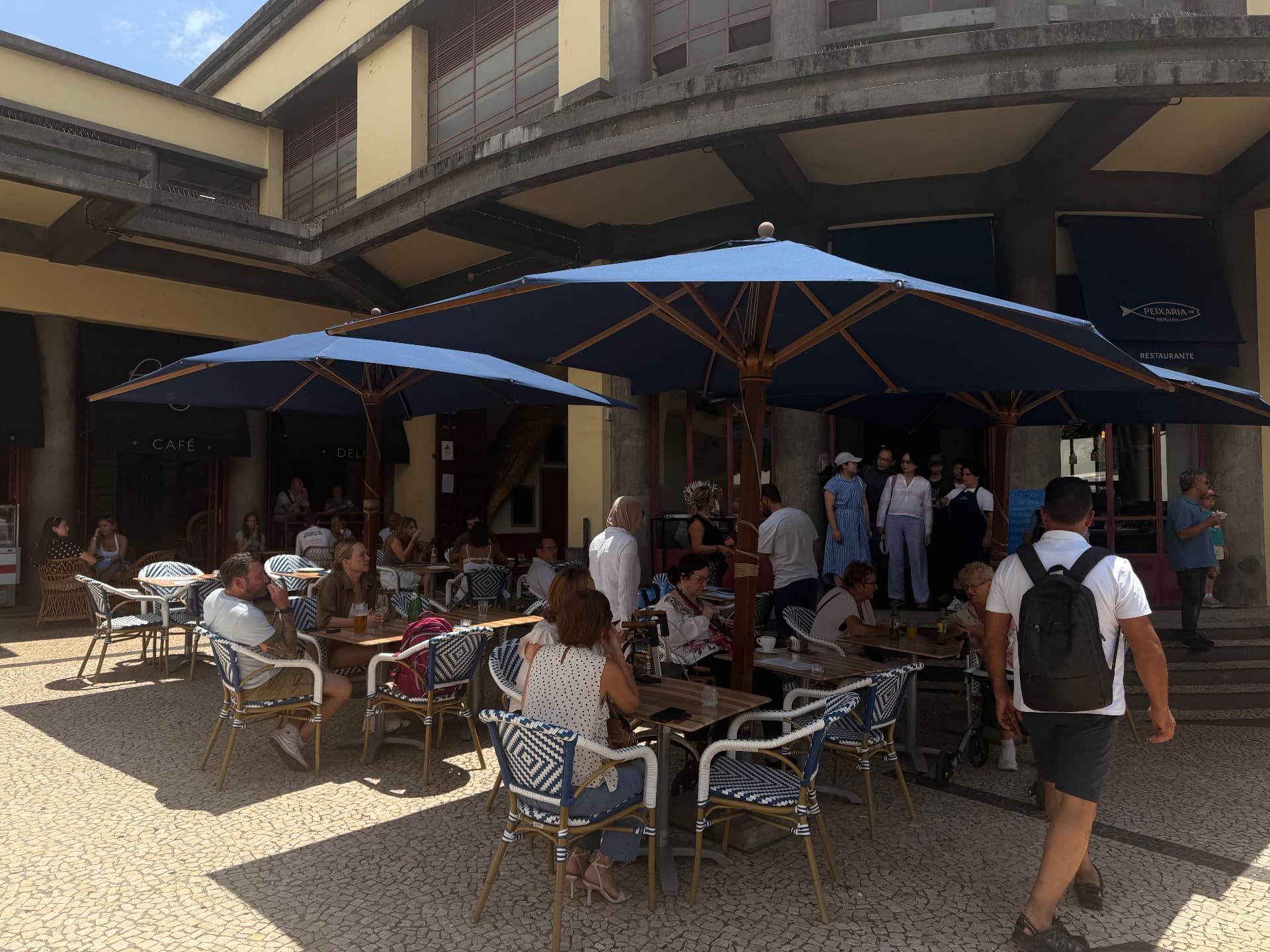 Busy cafe terraces under the colonnade of Mercado dos Lavradores, Funchal.