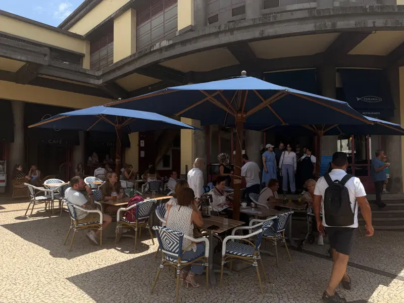 Busy cafe terraces under the colonnade of Mercado dos Lavradores, Funchal.