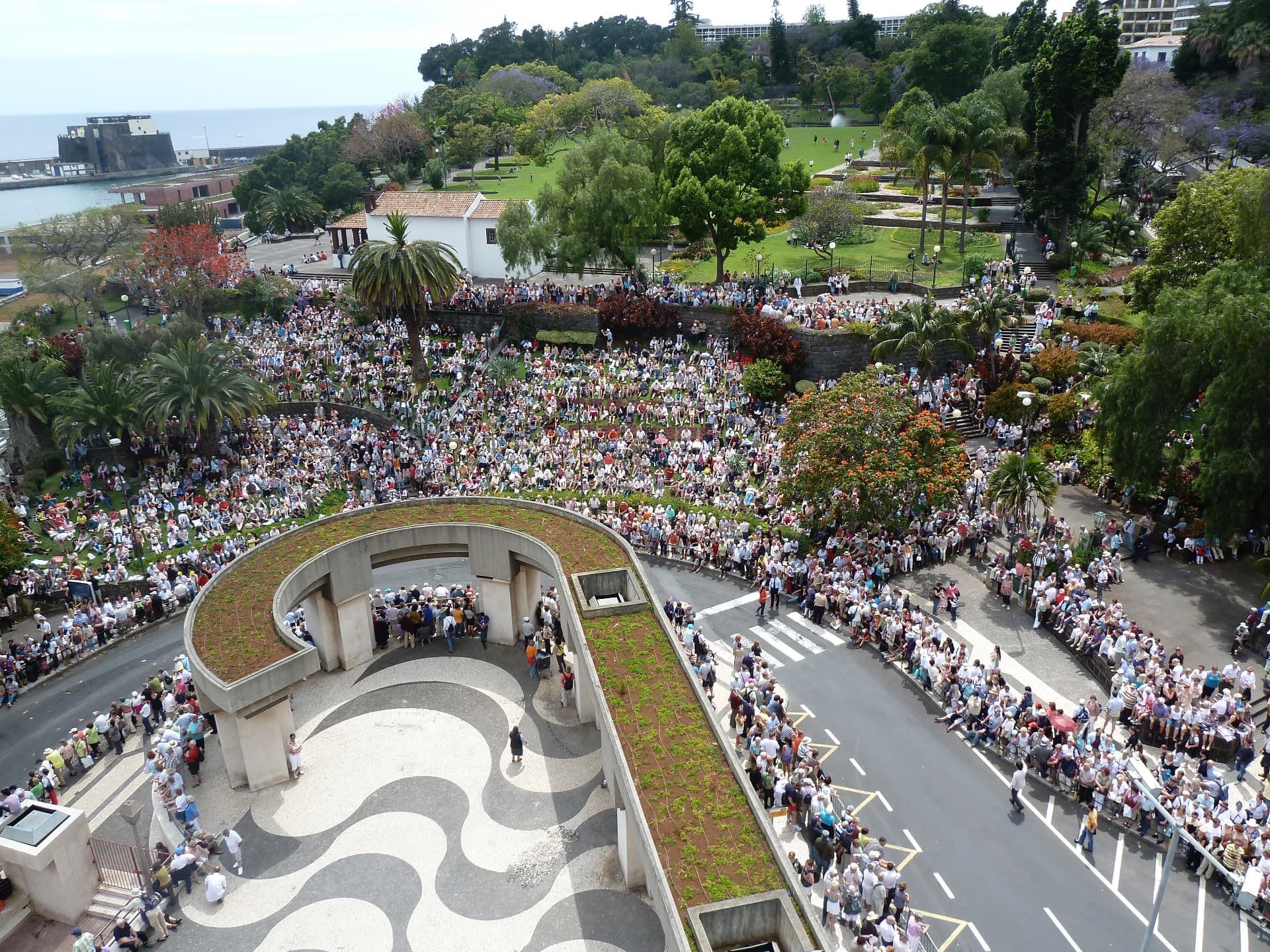 Crowds gathered around a landscaped plaza during the Madeira Flower Festival in Funchal.