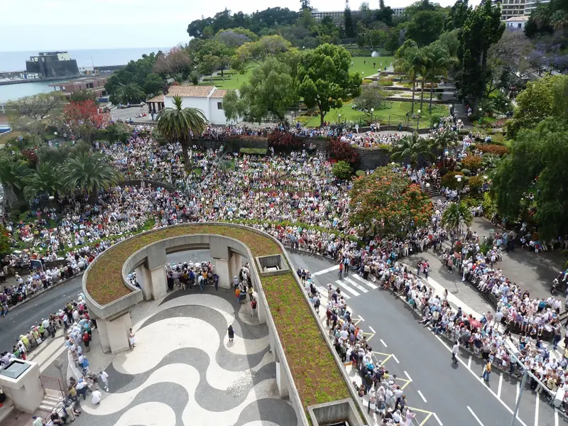 Crowds gathered around a landscaped plaza during the Madeira Flower Festival in Funchal.