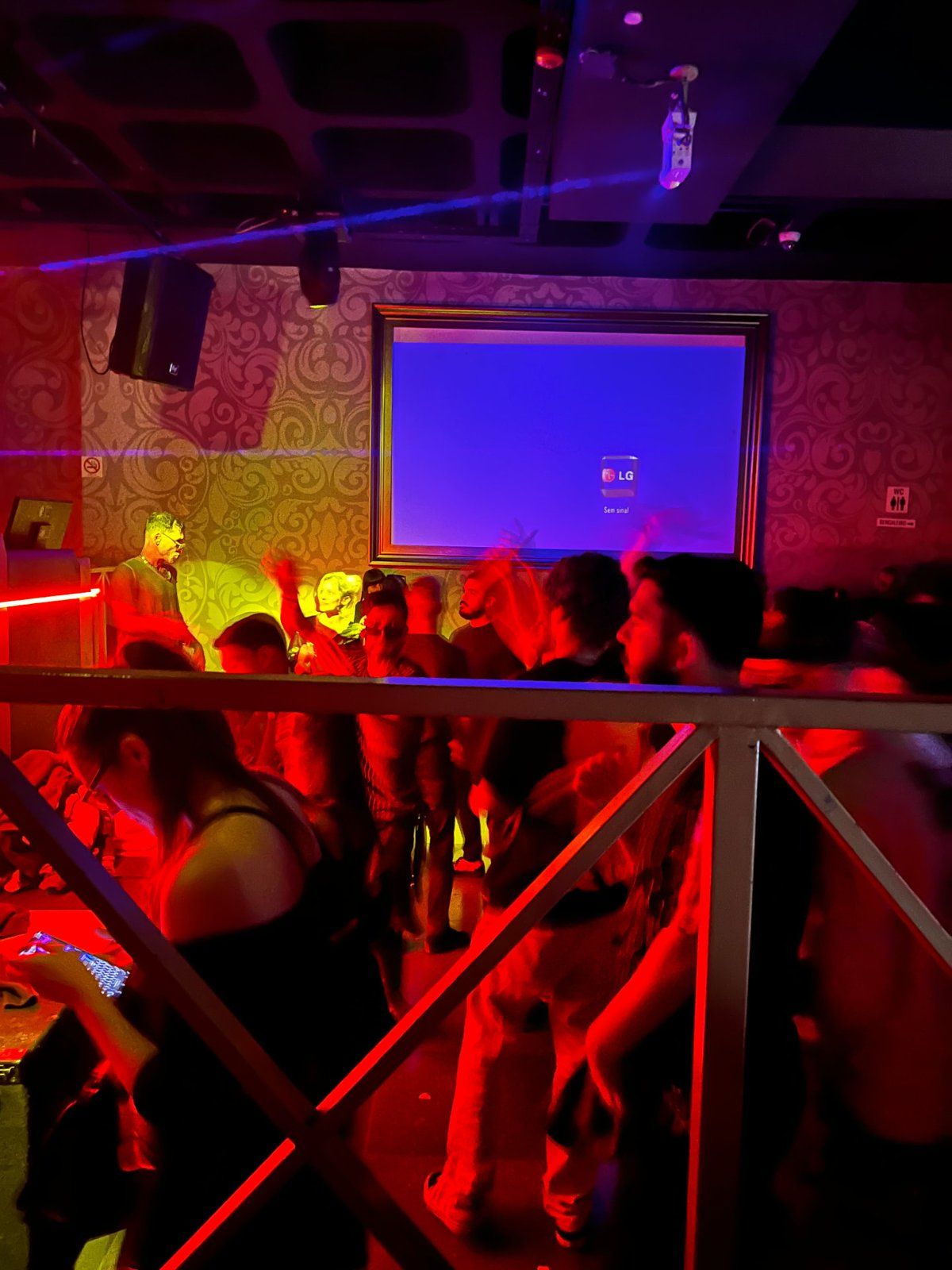 Clubbers dancing under red lights at Dubai Club nightclub in Funchal, Madeira