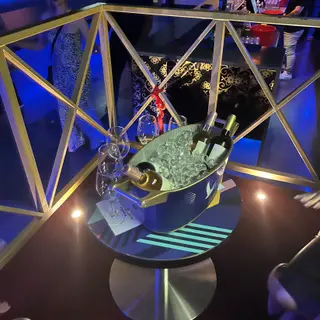 Wine bottles in an ice bucket on a nightclub table under blue lighting