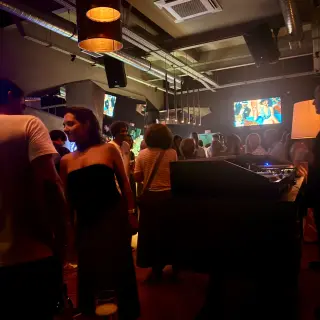 Busy night inside Groovy in Funchal, with a DJ booth, warm pendant lights and video screens