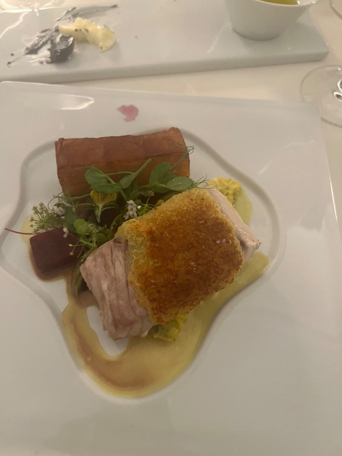 Prato principal de peixe com cobertura crocante e legumes no restaurante do Design Centre Nini Andrade Silva