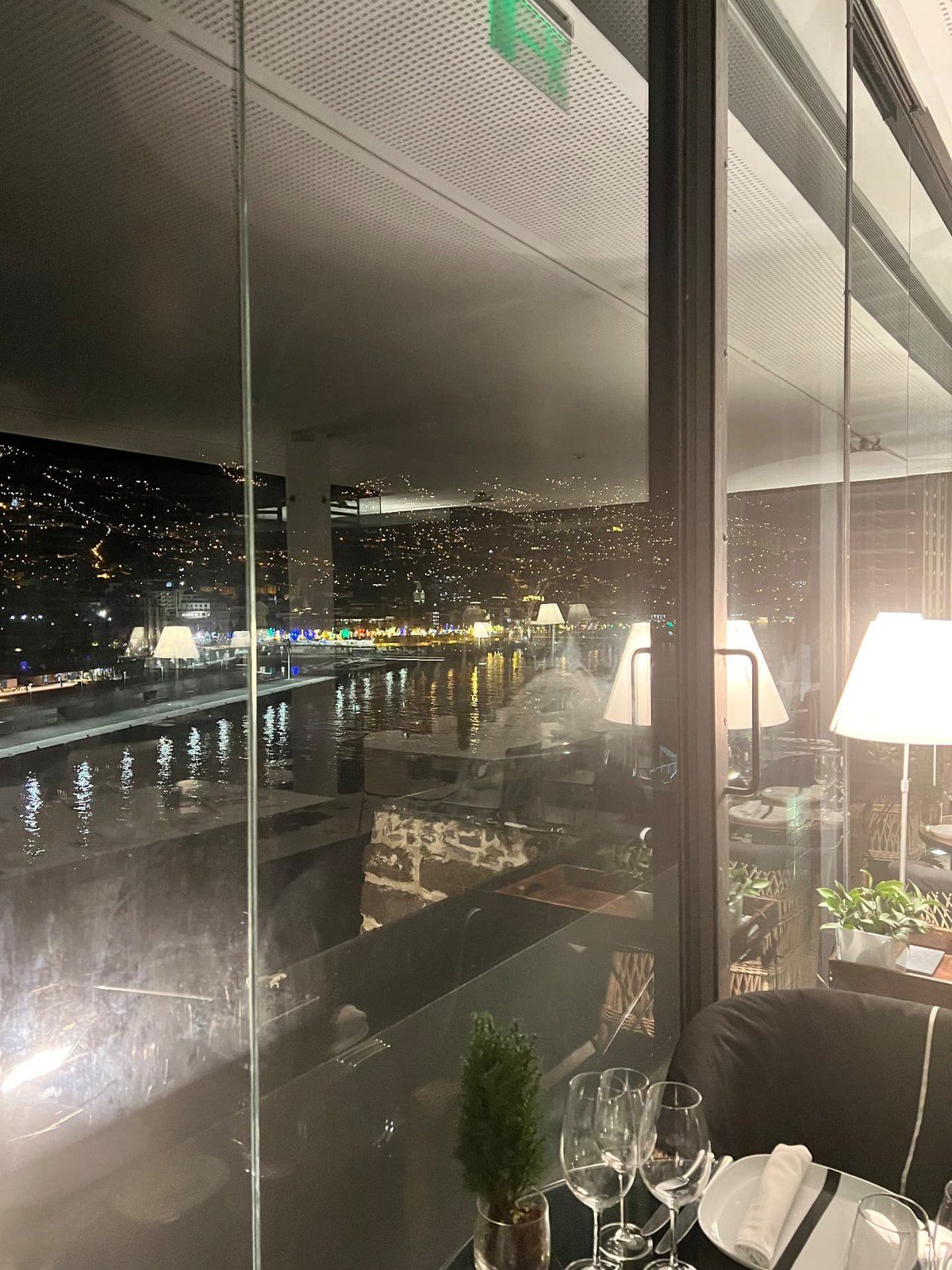 Restaurant table beside the panoramic Funchal harbour windows at Design Centre Nini Andrade Silva