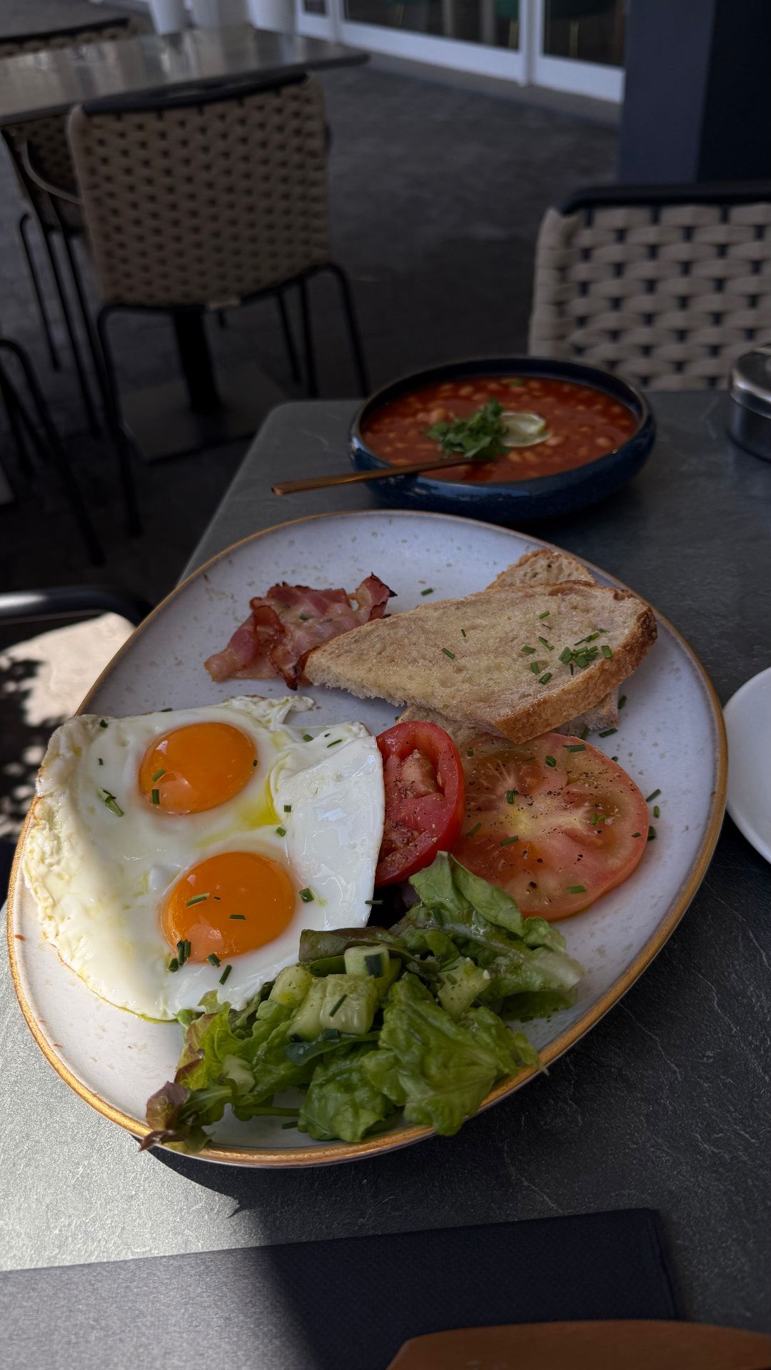 Full brunch breakfast with fried eggs, bacon, tomatoes and sourdough toast at Fuga Bistro Bar, Caniço de Baixo, Madeira