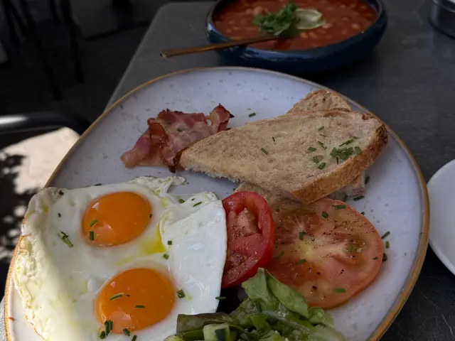 Full brunch breakfast with fried eggs, bacon, tomatoes and sourdough toast at Fuga Bistro Bar, Caniço de Baixo, Madeira