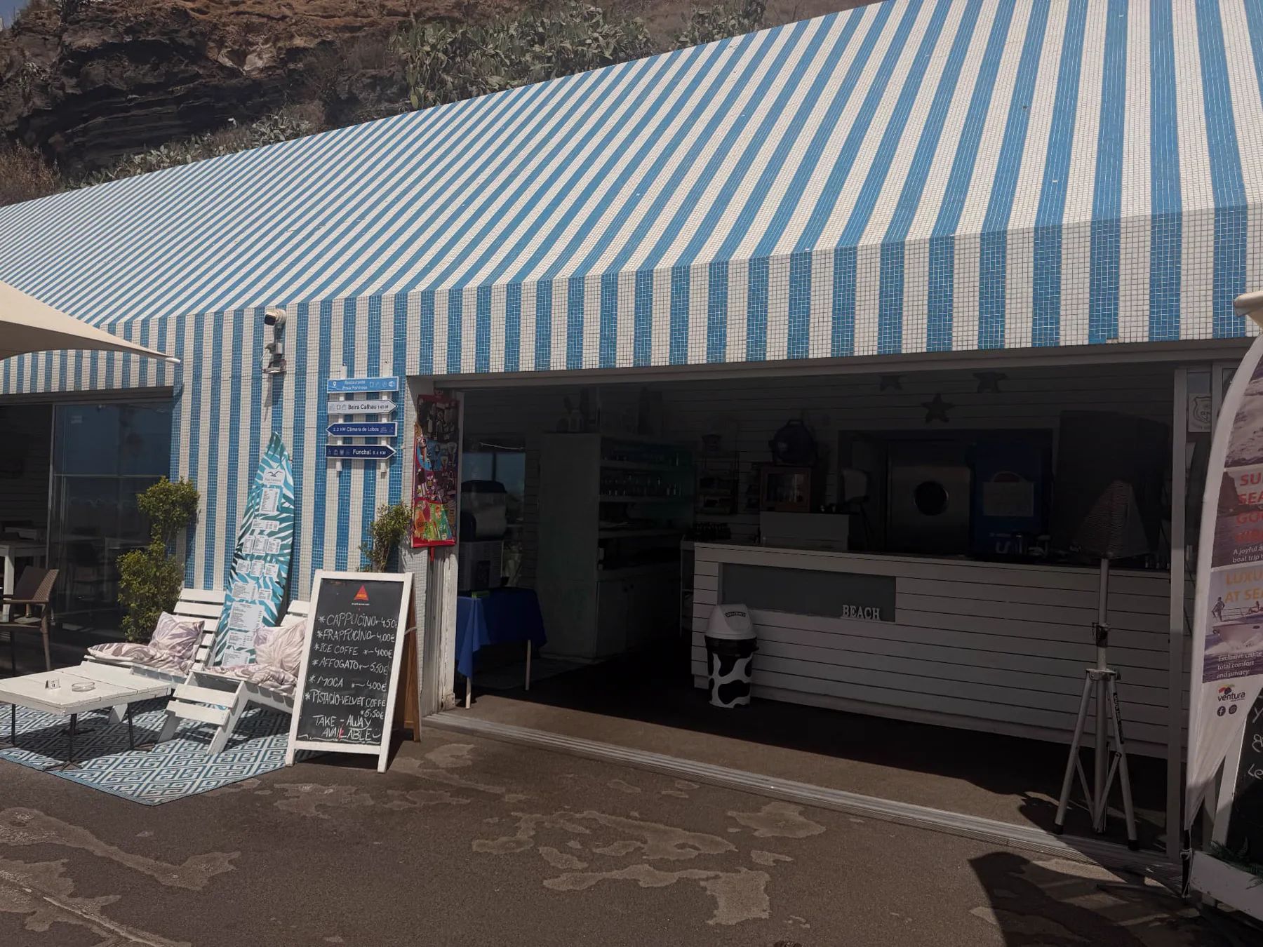 Blue-and-white tiled frontage and shaded outdoor tables at Restaurante Praia Formosa beside the beach in Funchal.