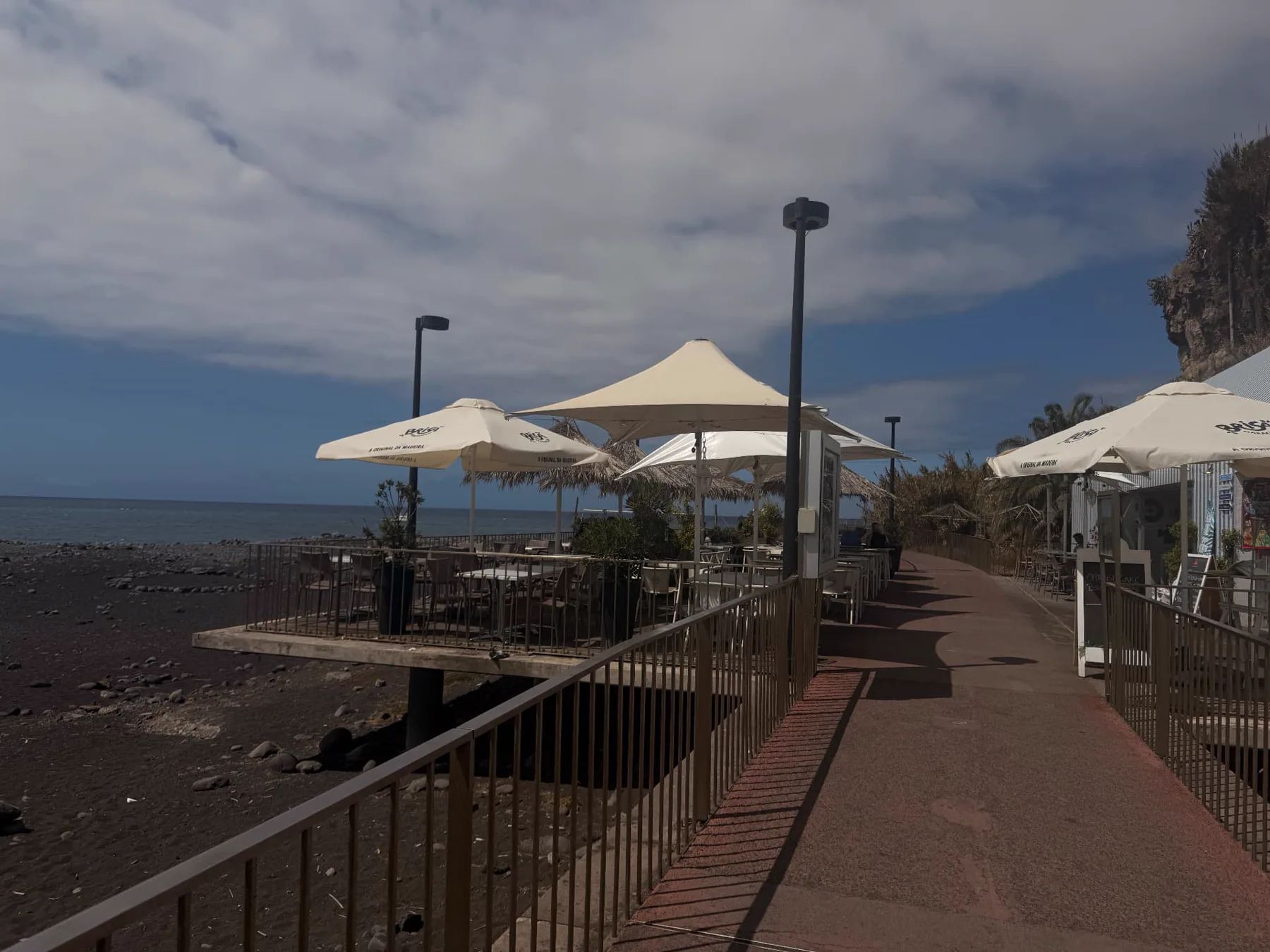 Restaurante Praia Formosa terrace overlooking the black-pebble beach and Atlantic Ocean in Funchal.