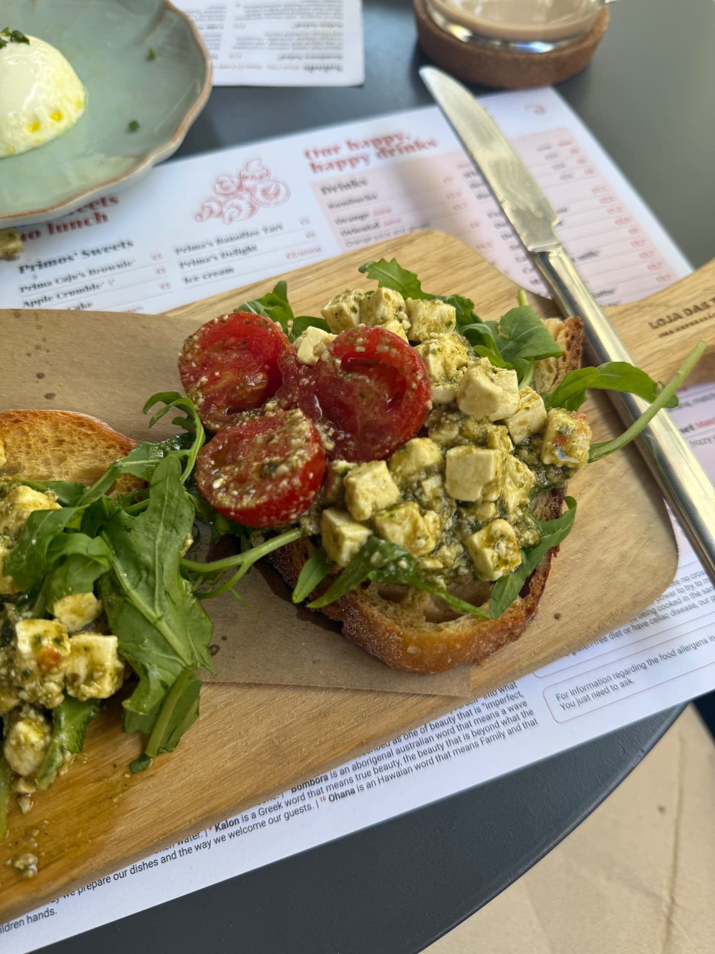 Sourdough toast topped with pesto, crumbled feta, rocket and cherry tomatoes at Prima Caju brunch cafe in Funchal, Madeira