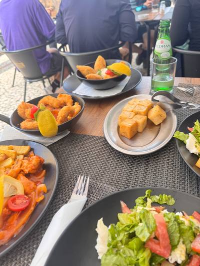 A table of Madeiran petiscos at Rota dos Sabores in Santa Cruz: breaded prawns, milho frito cubes, rissois and fresh salad
