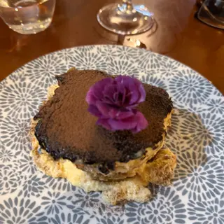 Tiramisu with cocoa dusting and flower garnish at 5 Sentidos restaurant, Funchal, Madeira