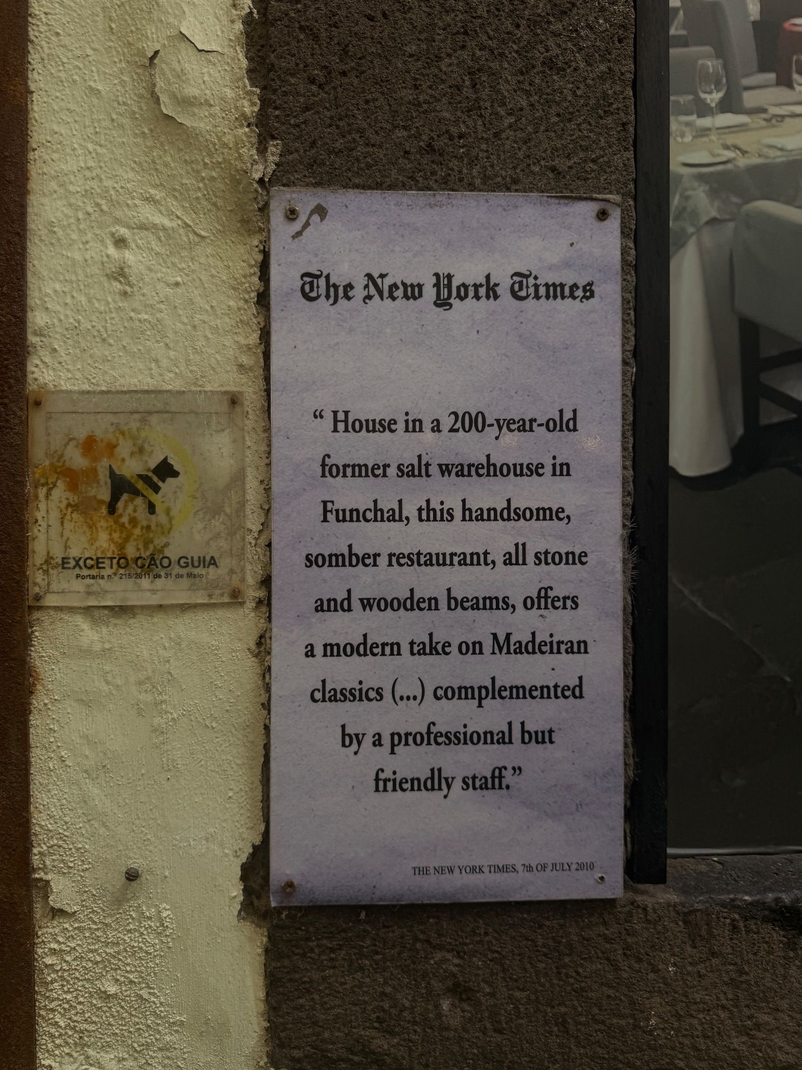 Placa com crítica do New York Times junto à janela da Armazém do Sal restaurante e sinal