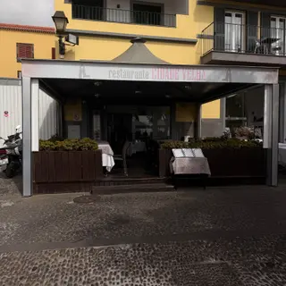 Cidade Velha restaurant with covered terrace, wooden planters and menus displayed outside