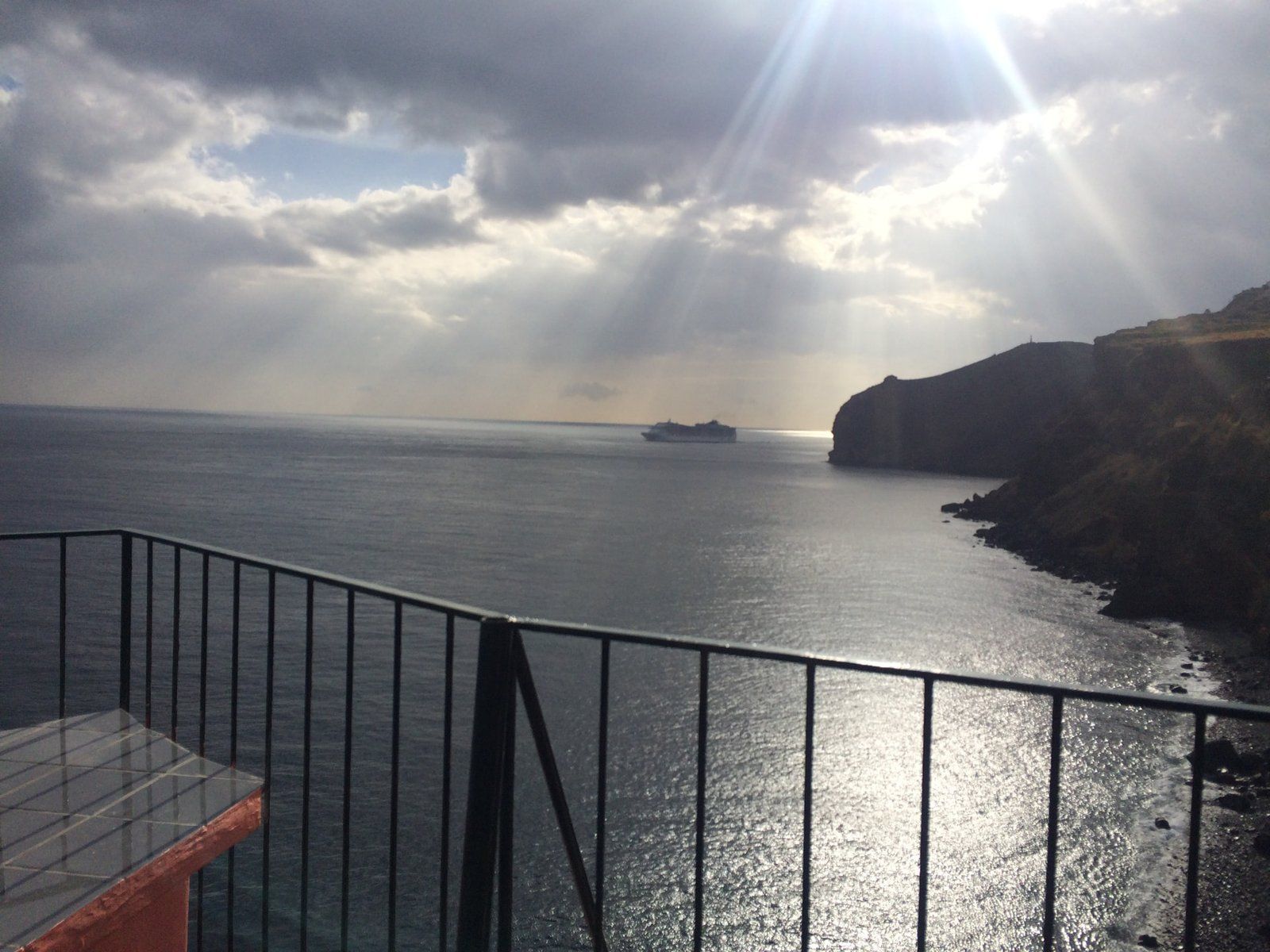 Sun rays breaking through clouds over the Atlantic from the terrace of Inn & Art restaurant, Reis Magos, Madeira