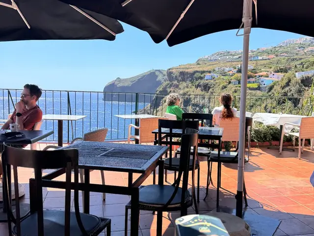 Shaded terrace tables at Inn & Art restaurant in Reis Magos, Canico de Baixo, overlooking the Atlantic and the Madeira coastline