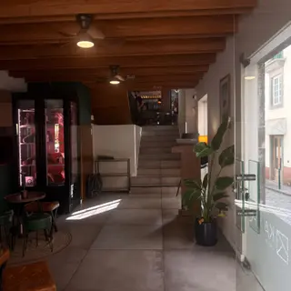 Restaurant entrance with meat display cabinet, wooden ceiling and stairs to a dining area