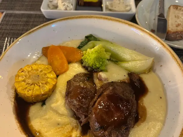 Slow-cooked beef cheeks in red wine jus on creamy mashed potato with corn, carrot, romanesco and pak choi at Laranjinha Bistro & Grill in Caniço, Madeira