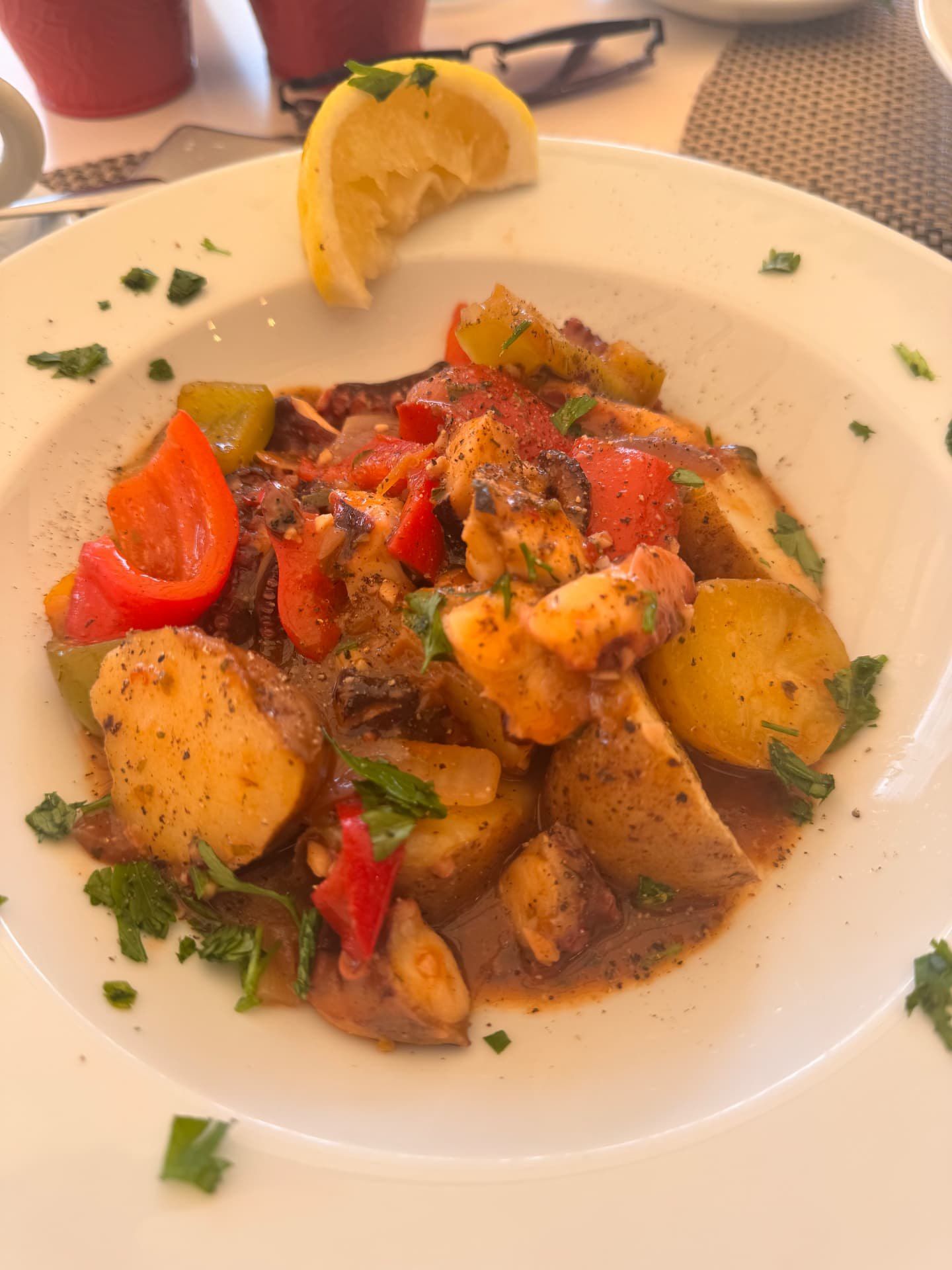 Polvo com batatas assadas, pimentos vermelhos e verdes, salsa fresca e uma fatia de limão no Munchies Restaurante & Bar, no Caniço, na Madeira