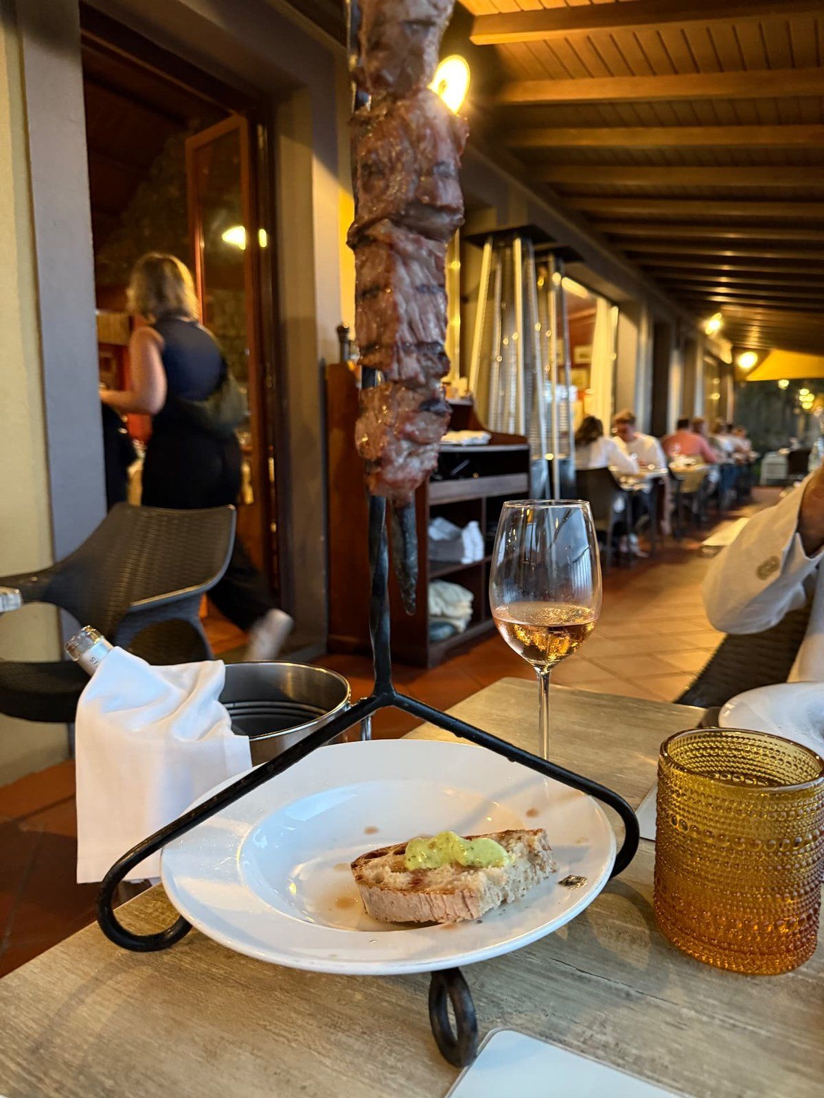 Traditional espetada beef skewer hanging over the table at Quinta do Furão restaurant, Santana, Madeira, with bolo do caco and Madeira wine