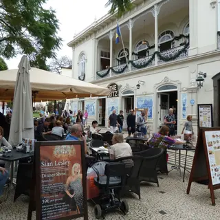 The busy esplanade of The Ritz Cafe on Avenida Arriaga in Funchal, Madeira, with its Belle Epoque facade and azulejo tile panels