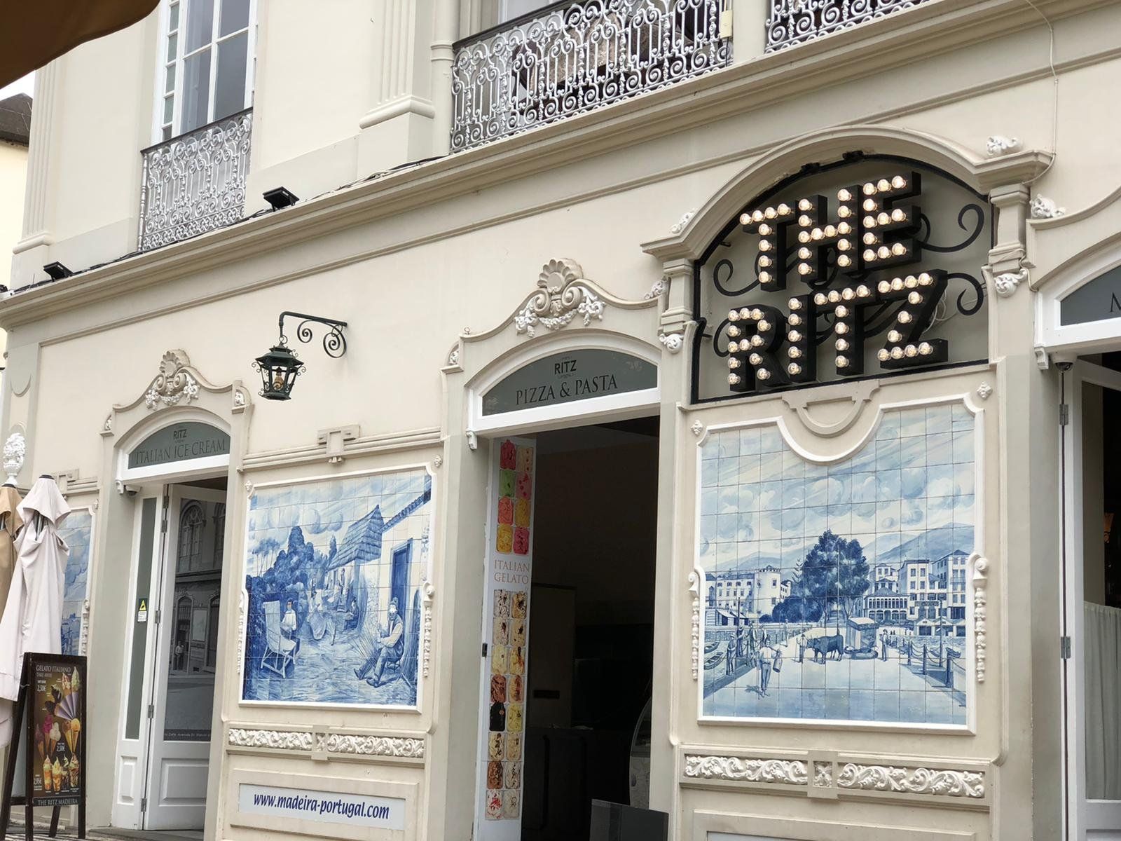 The ornate facade of The Ritz Madeira in Funchal with its lightbulb sign and blue azulejo tile panels of old Funchal