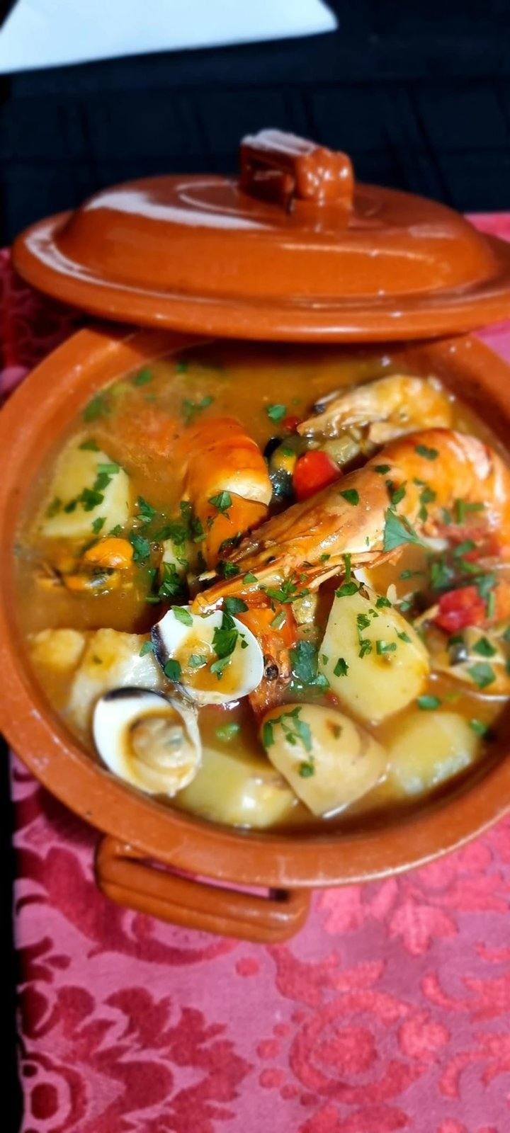 Caldeirada de marisco seafood stew with prawns, clams and potatoes served in a clay pot at Sabor a Fado restaurant, Funchal Old Town, Madeira