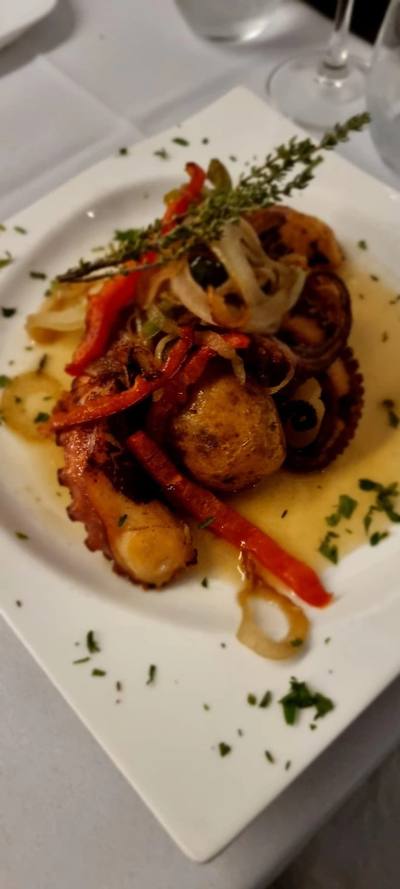 Grilled octopus with roasted peppers, onions and potato garnished with herbs at Sabor a Fado restaurant, Funchal Old Town, Madeira