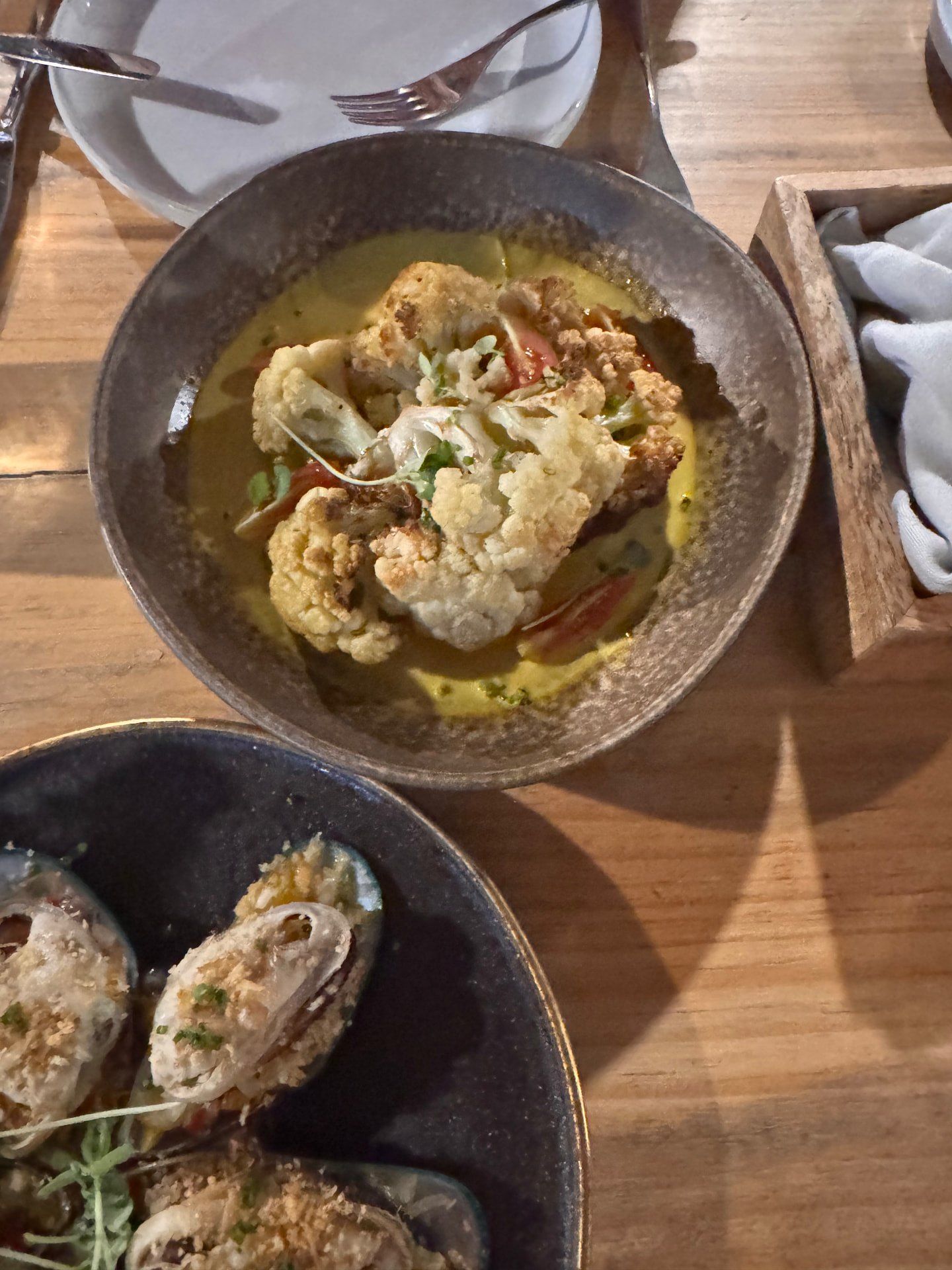 Sharing dishes of baked mussels and roasted cauliflower in turmeric sauce at Terra Food Concept in Funchal, Madeira