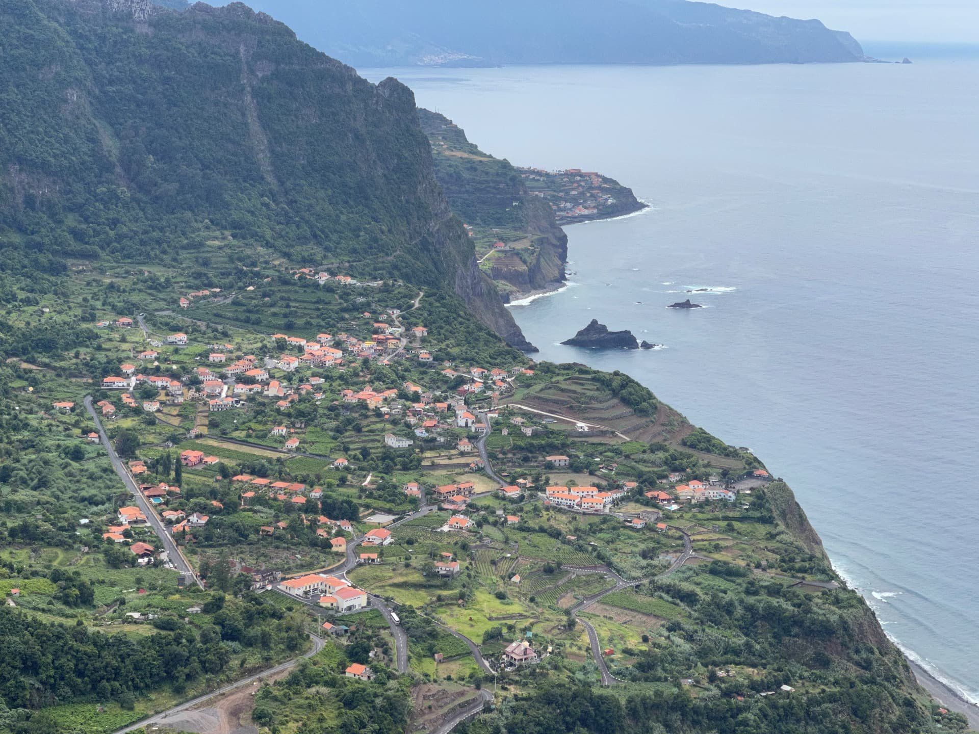 Arco de Sao Jorge village and north coast cliffs with offshore sea stack, Madeira