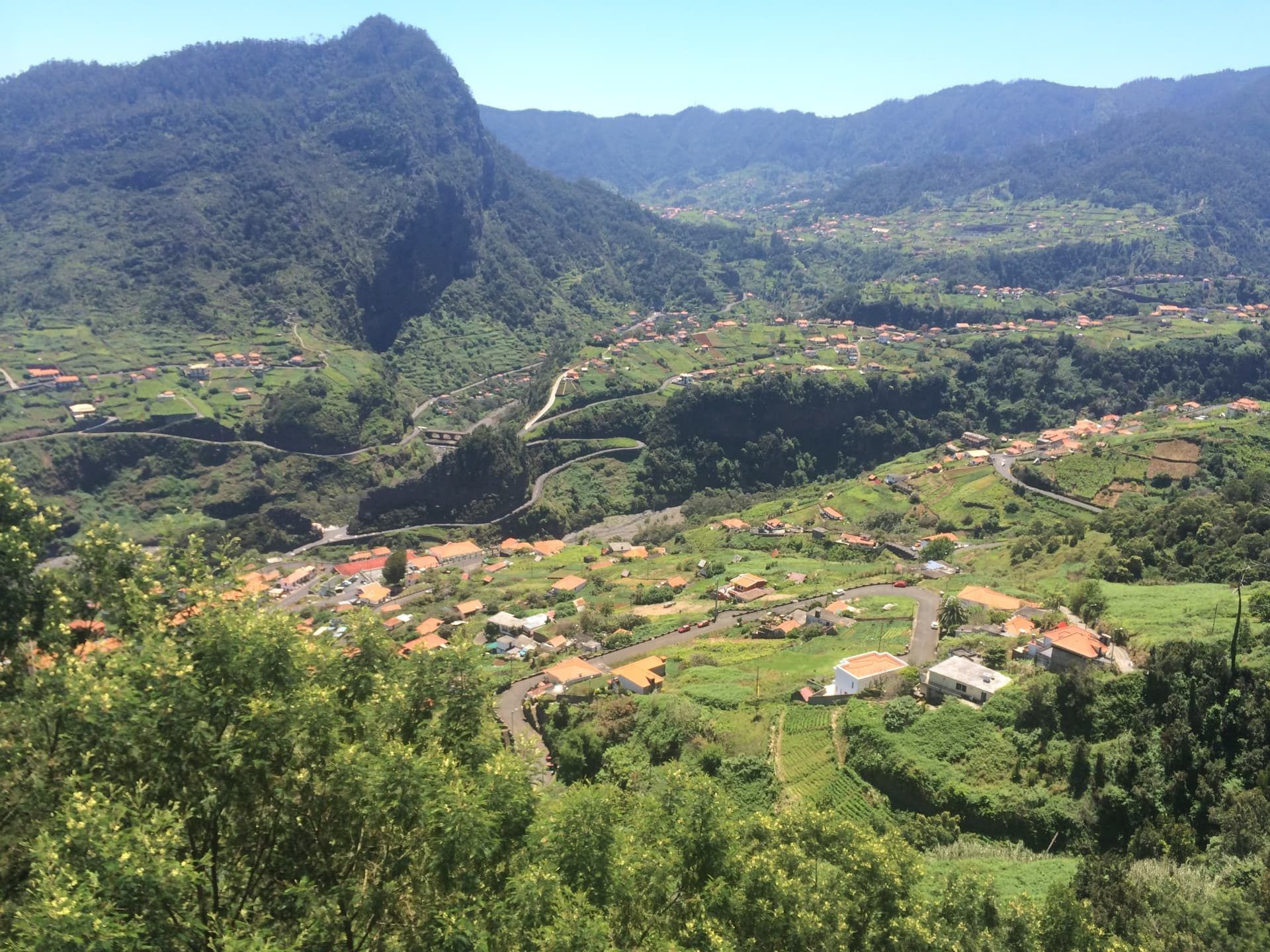 Estrada sinuosa que atravessa a vila do Faial, entre telhados alaranjados e jardins em socalcos